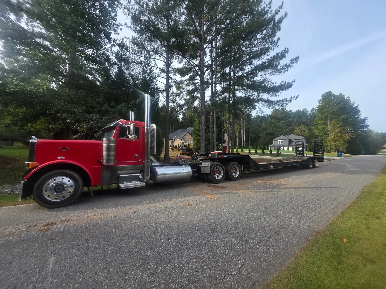 Red Titan Built Peterbilt truck with a lowboy trailer hauling in for land clearing in Mooresville, NC