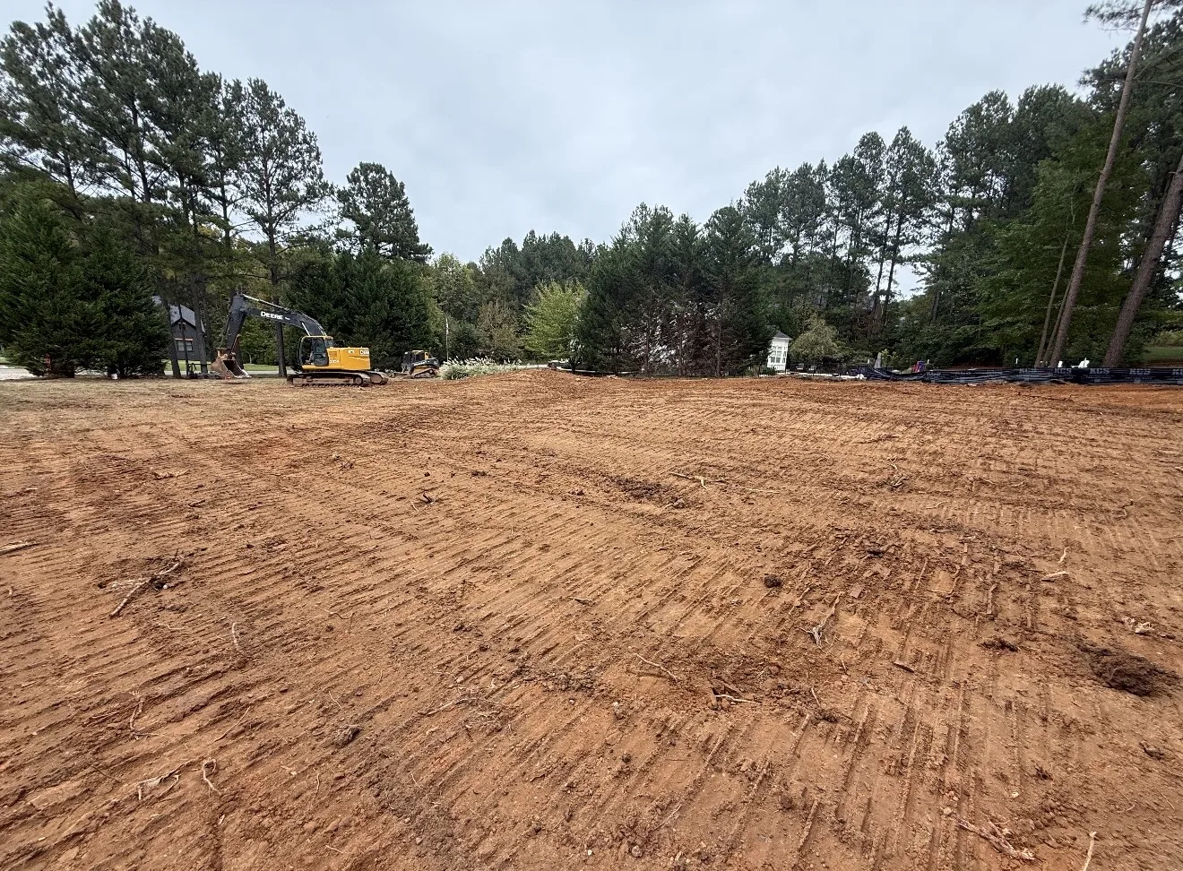 Cleared and prepped lot with an excavator and silt fence in Mooresville, NC