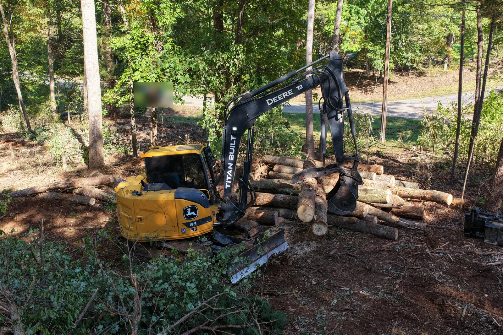 Titan Built Earthworks excavator using a hydraulic thumb to stack timber on a land clearing job near Lake Norman